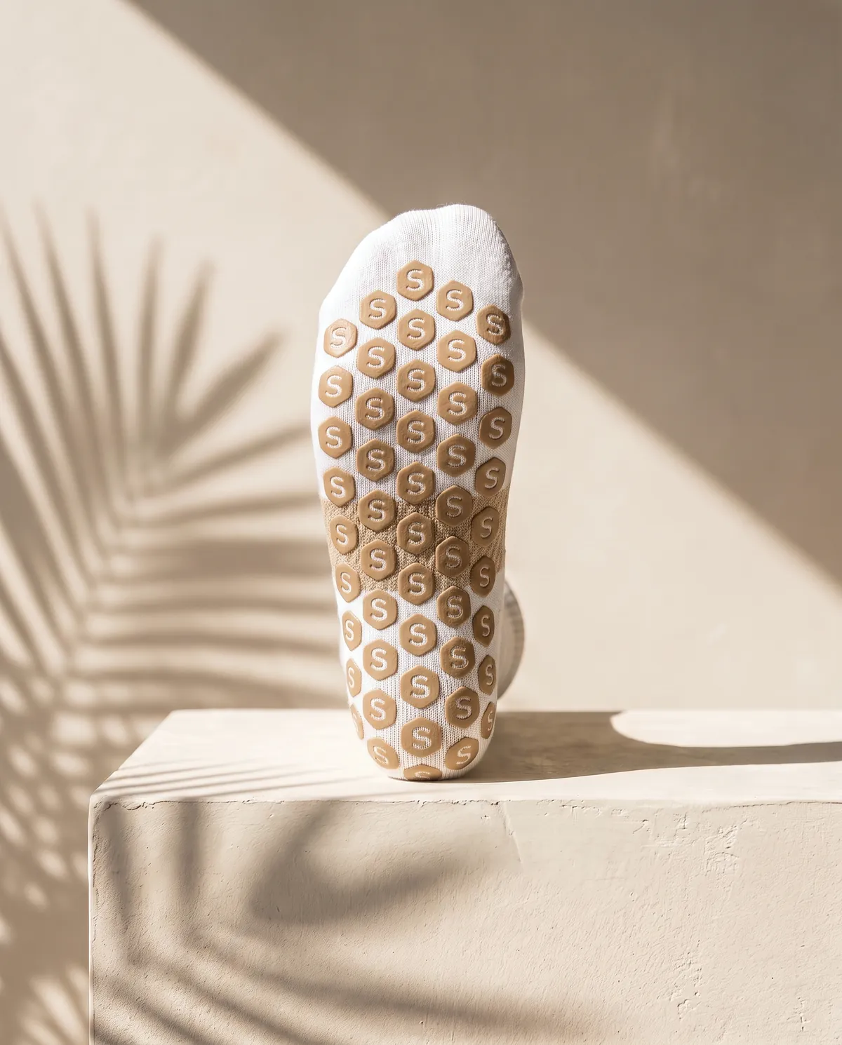 The sole of a Suelo sock, covered in hex grip pads with the arch band across the middle.